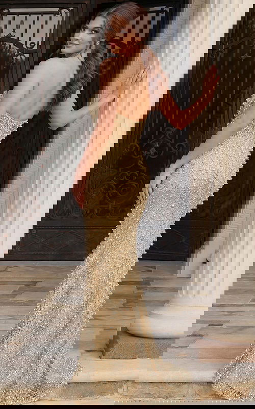 Back view of a beaded halter gown with open back and fitted column silhouette