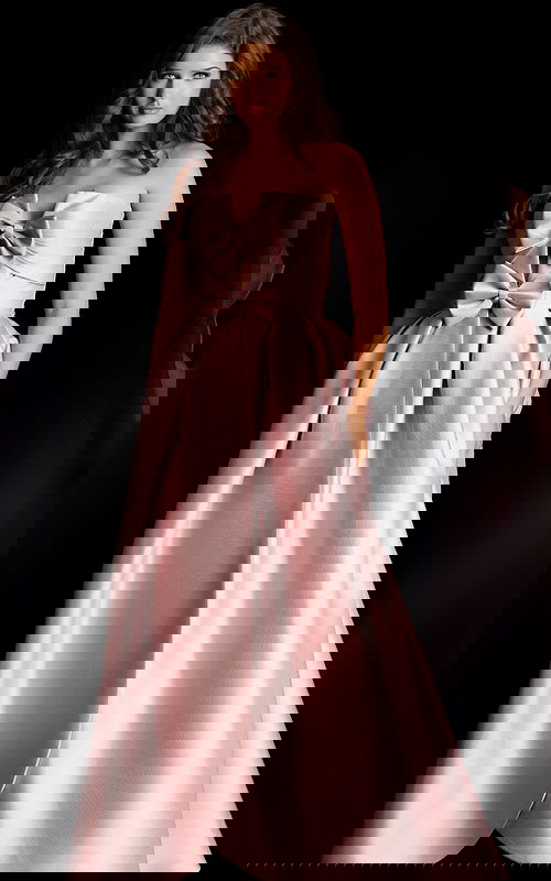 Glamorous strapless formal gown with oversized bow accents and voluminous silhouette