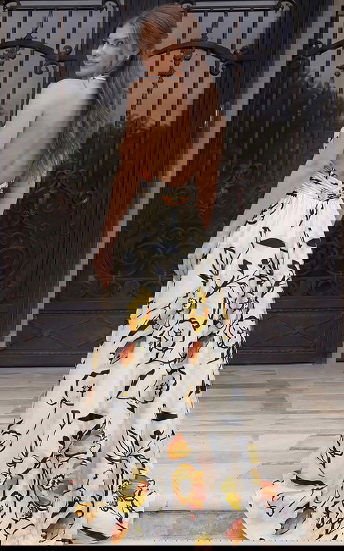 Open-back halter gown with flowing skirt and bold floral print in lightweight fabric