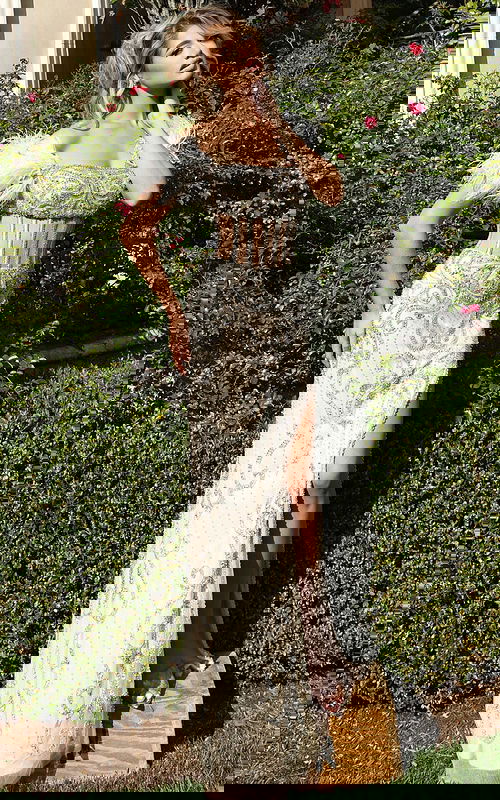 Front view of beaded gown with feather off-shoulder sleeves and corset bodice