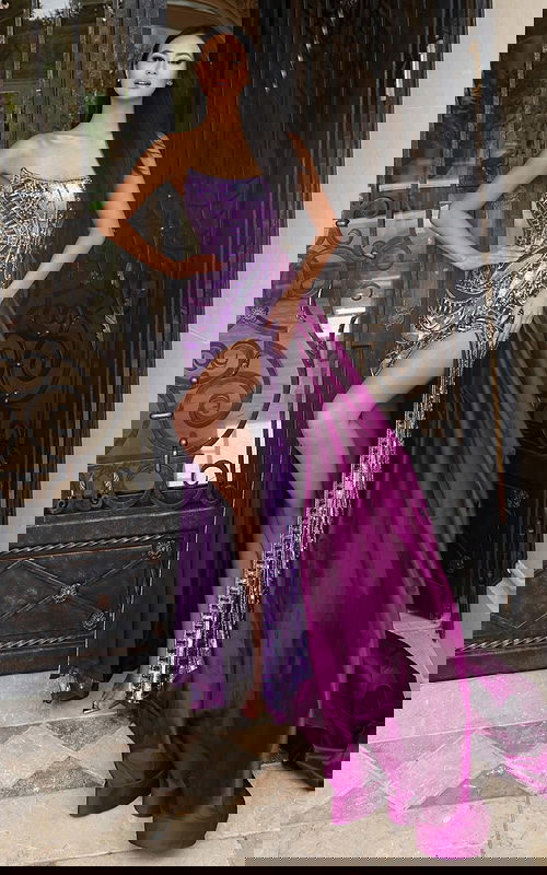 Purple beaded prom dress with high slit and dramatic overskirt