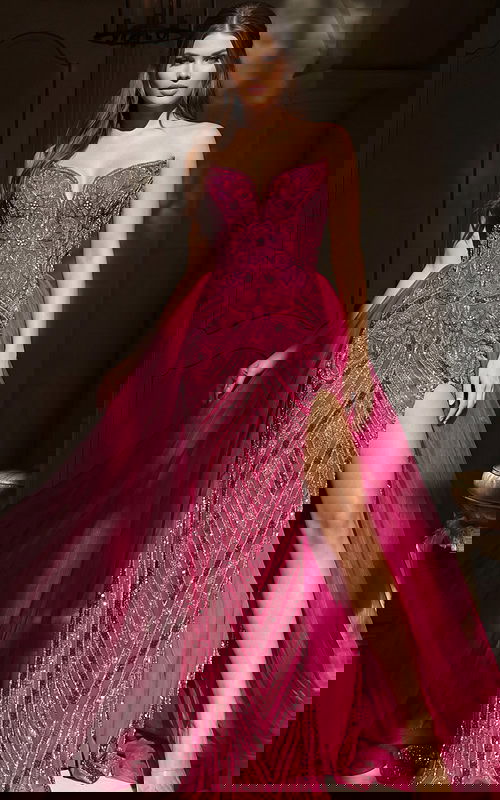 Strapless beaded gown with fitted bodice, high slit, and flowing tulle overskirt for a dramatic layered look